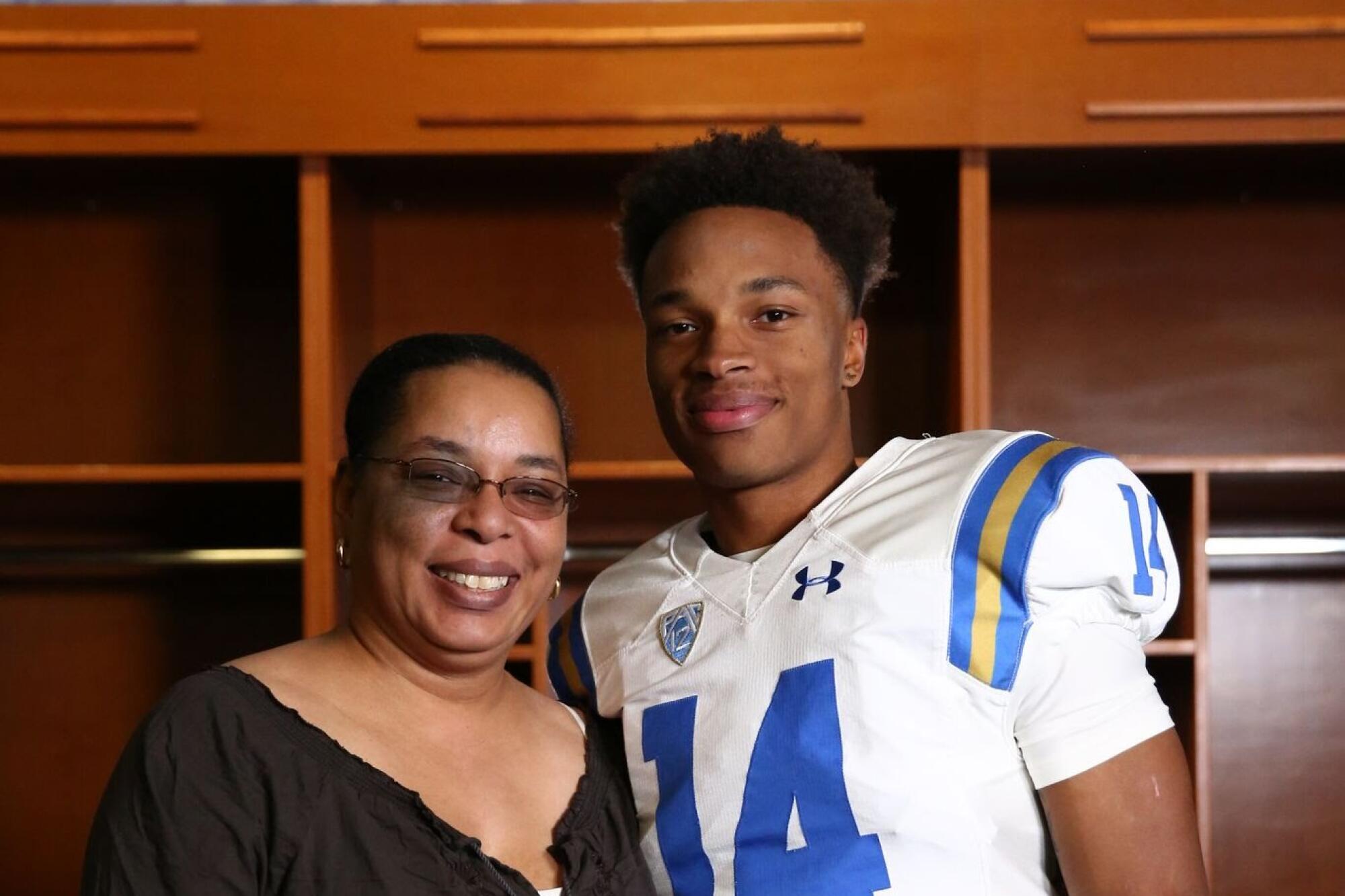 UCLA quarterback Dorian Thompson-Robinson stands beside his mom, Melva Thompson-Robinson, in the Rose Bowl locker room