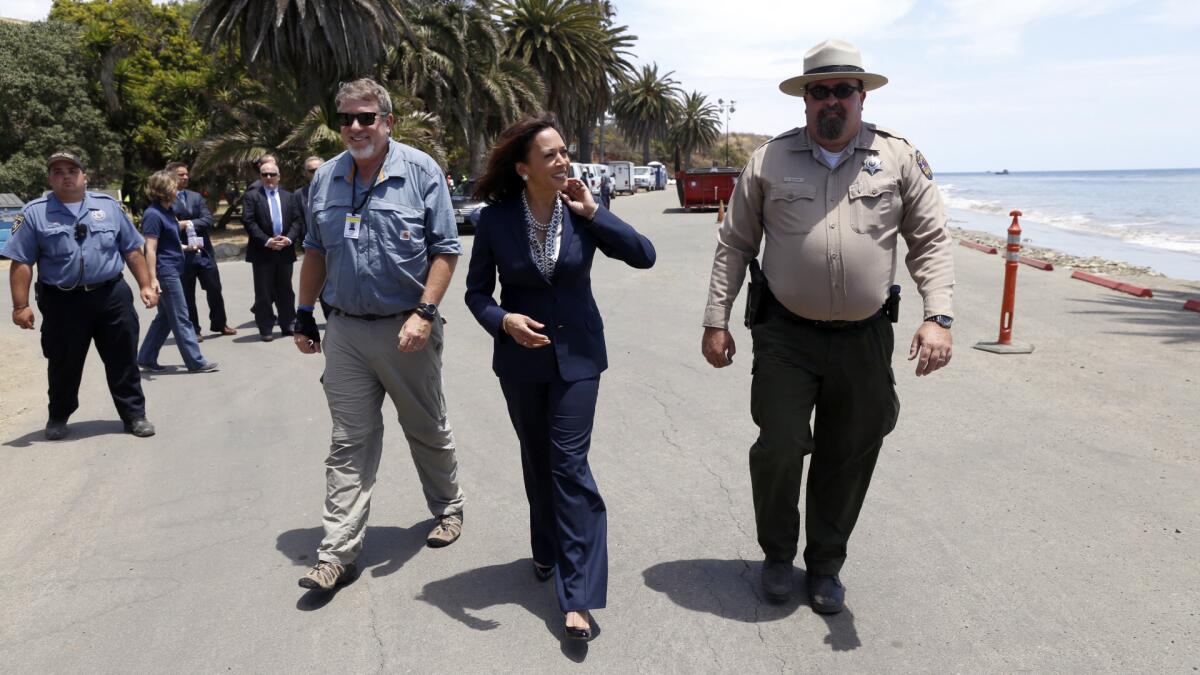 State Atty. Gen. and U.S. Senate candidate Kamala Harris, center, is briefed by Tyson Butzke, right, a superintendent with California State Parks, and Tom Cullen, left, of the Department of Fish and Wildlife, at Refugio State Beach on Thursday.