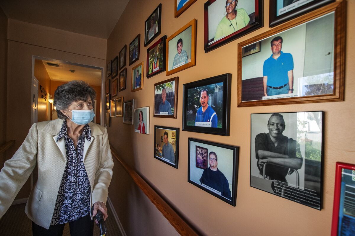 Norma Jean Vescovo looks at a wall of photographs