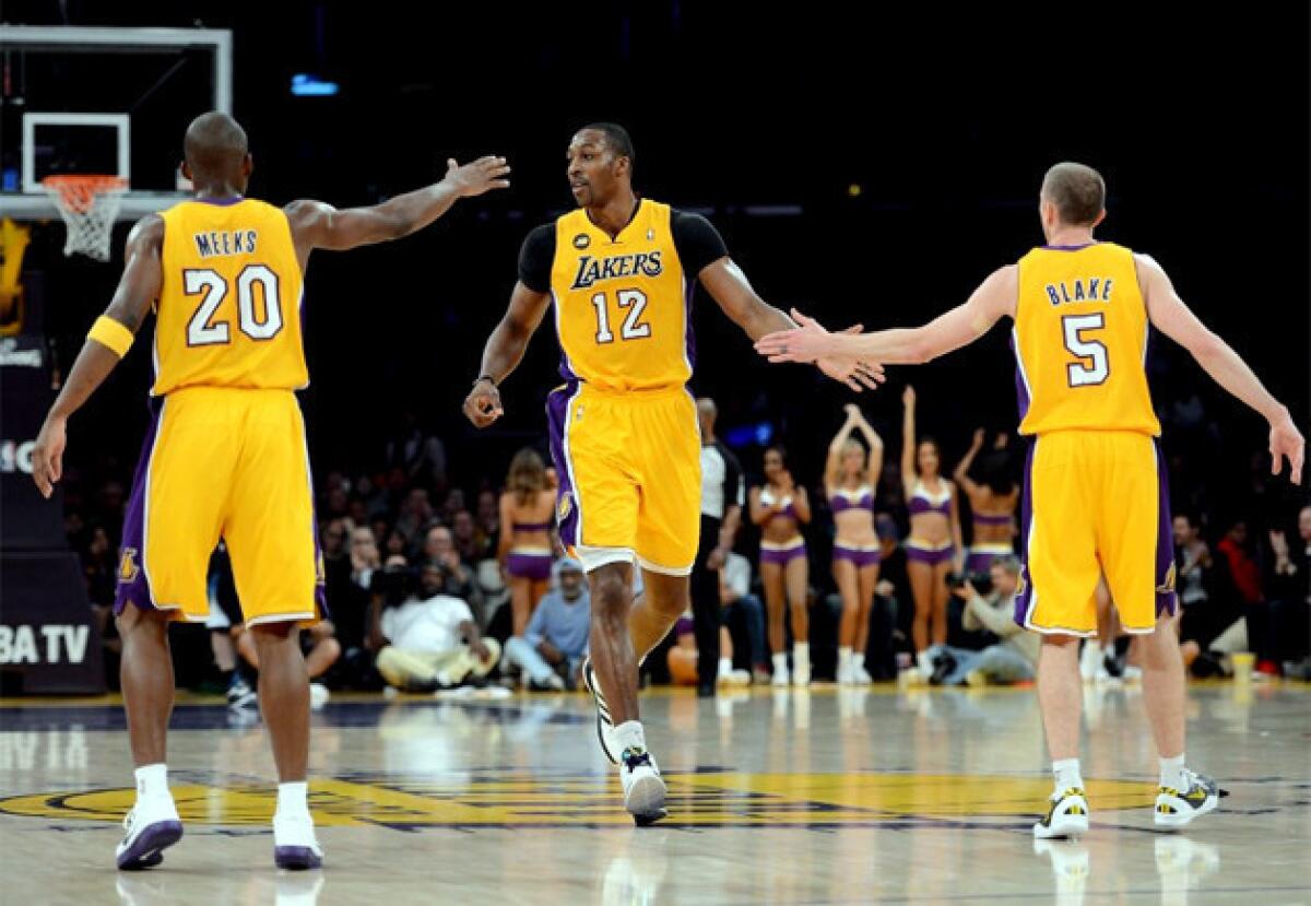 Lakers' Dwight Howard (12) celebrates his basket with guards Jodie Meeks and Steve Blake.