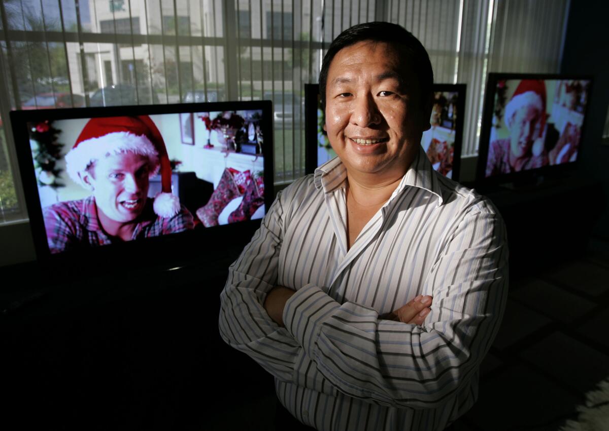 Vizio CEO William Wang smiles in front of a monitor