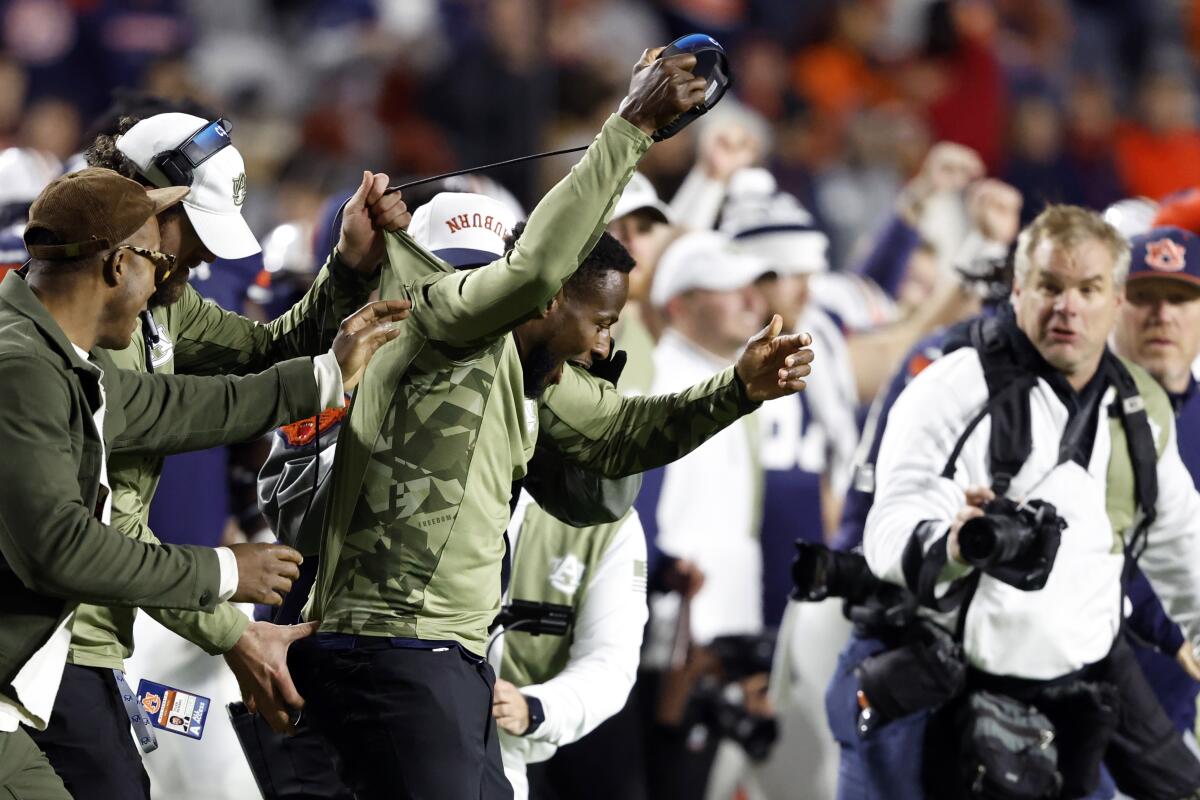 Auburn interim head coach Carnell Williams, center, reacts to his first win after the team defeated Texas A&M in an NCAA college football game Saturday, Nov. 12, 2022, in Auburn, Ala. (AP Photo/Butch Dill)