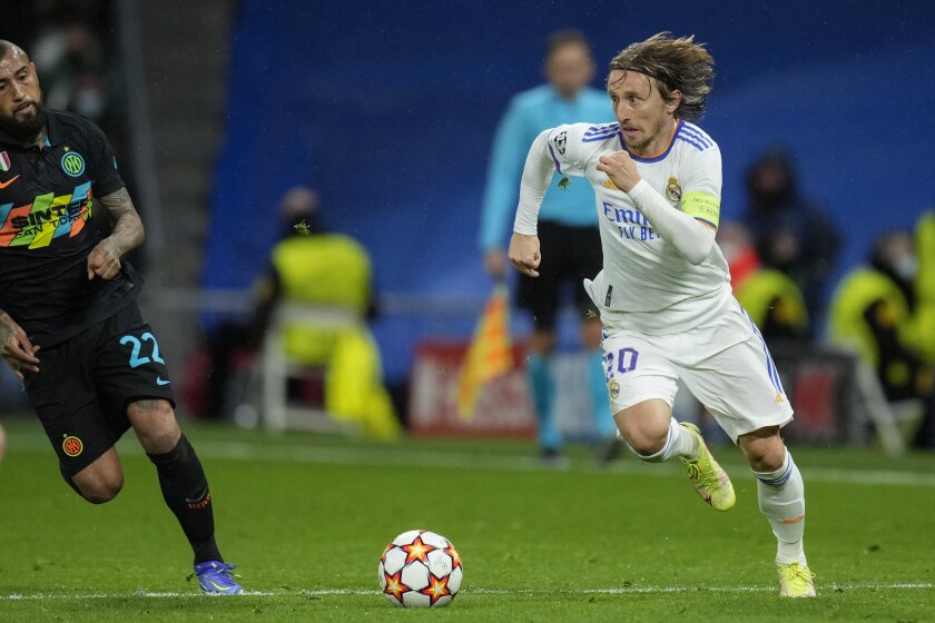 Real Madrid's Luka Modric, right, runs with the ball next to Inter Milan's Arturo Vidal during the Champions League Group D soccer match between Real Madrid and Inter Milan at the Santiago Bernabeu stadium, in Madrid, Spain, Tuesday, Dec. 7, 2021. Real Madrid won 2-0. (AP Photo/Bernat Armangue)