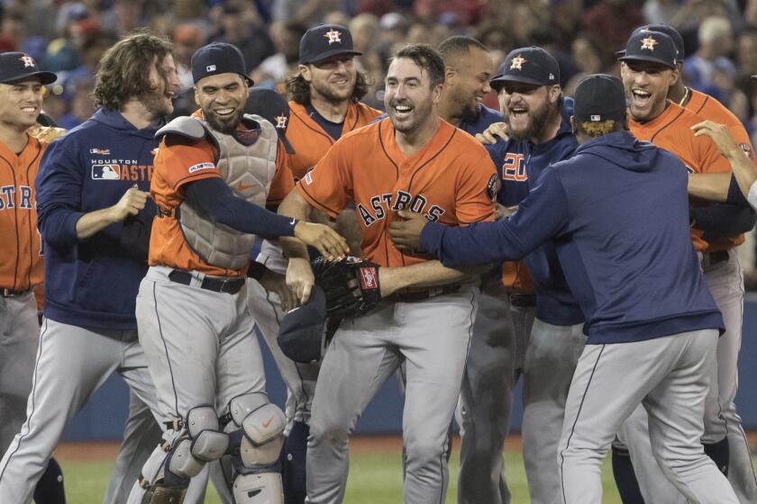 Houston Astros starting pitcher Justin Verlander, center, is mobbed by teammates after pitching a no-hitter against the Toronto Blue Jays in a baseball game in Toronto, Sunday, Sept. 1, 2019. (Fred Thornhill/The Canadian Press via AP)