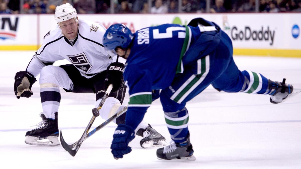Kings defenseman Matt Greene and Canucks defenseman Luca Sbisa (5) battle for control of the puck during the first period Wednesday night.