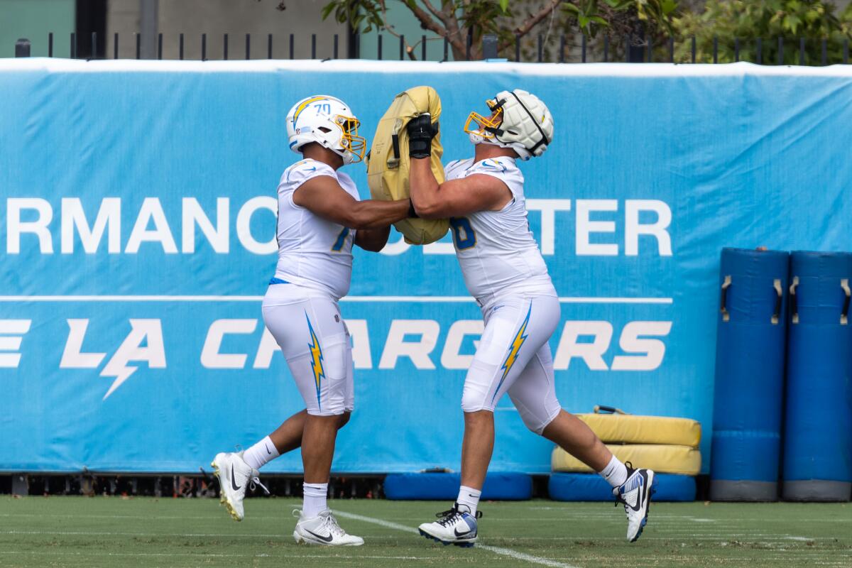 Starting Chargers offensive tackles Rashawn Slater (left) and Joe Alt combine on a blocking drill during practice. 