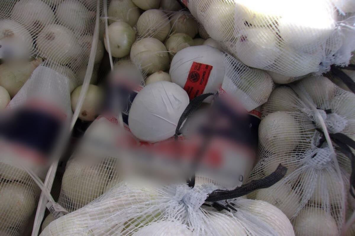 Small, white packages of methamphetamine mixed in among sacks of onions