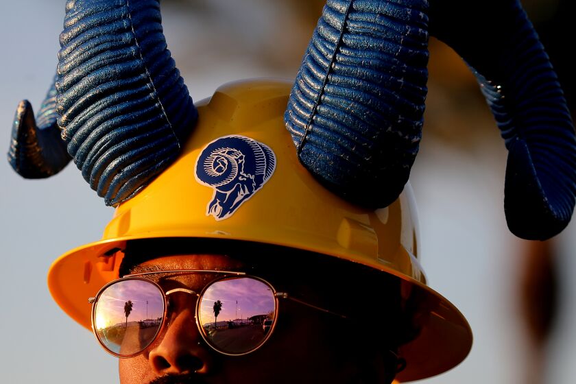 INGLEWOOD, CALIF. - FEB. 2, 2022. A Rams fan poses for pictures outside of SoFi Stadium in Inglewood.
