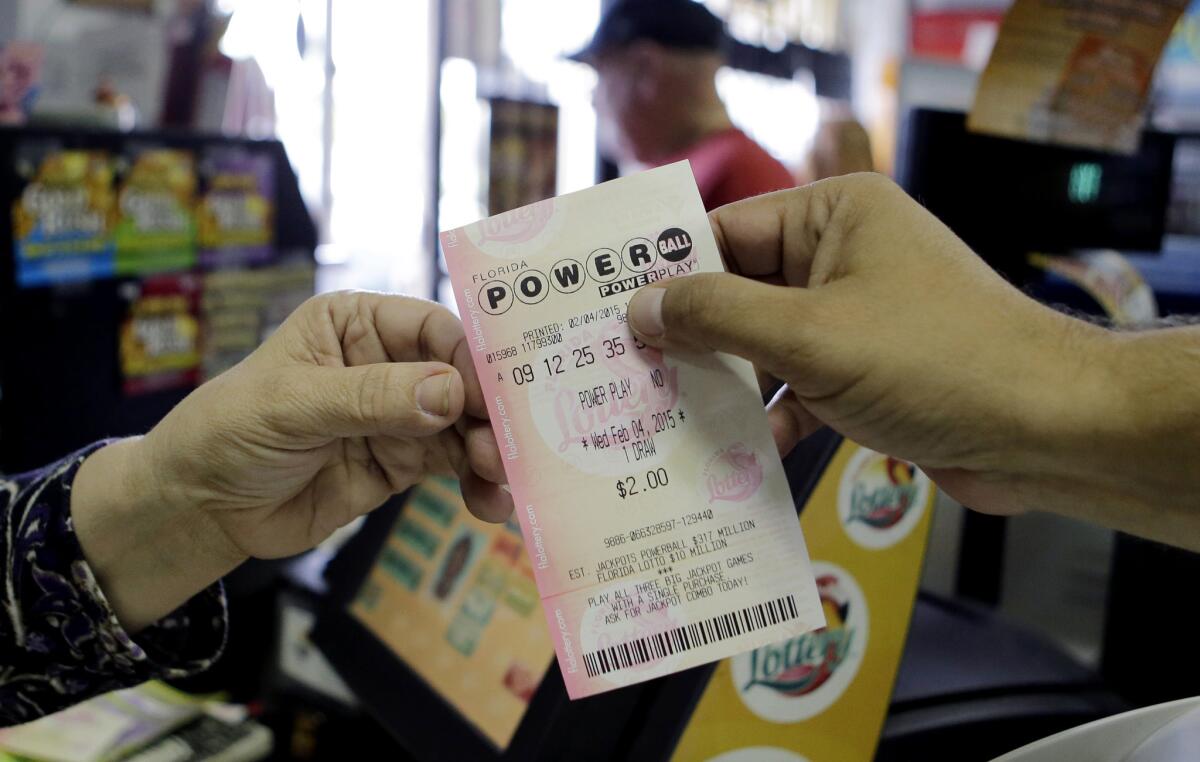 A store clerk hands a customer his Powerball ticket at a grocery store in Florida.