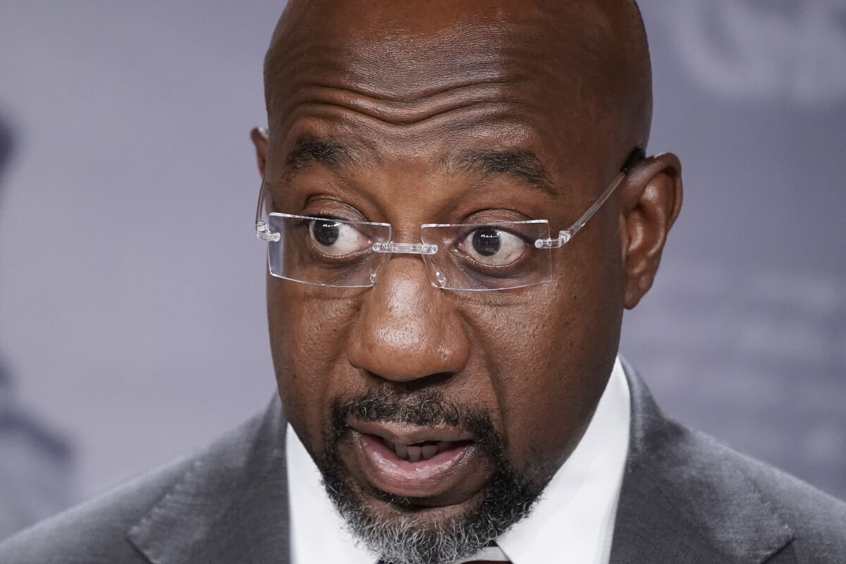 FILE - Sen. Raphael Warnock, D-Ga., speaks to reporters at the Capitol in Washington, July 26, 2022. Warnock of Georgia is urging the U.S. Treasury secretary to consider “maximum flexibility” for automakers and consumers in implementing a revised tax credit for Americans buying electric vehicles. The Democratic senator sent a letter to Treasury Secretary Janet Yellen on Friday, Sept. 23, raising concerns that changes to the tax credit President Joe Biden signed into law last month could place some automakers at a competitive disadvantage. (AP Photo/J. Scott Applewhite, File)