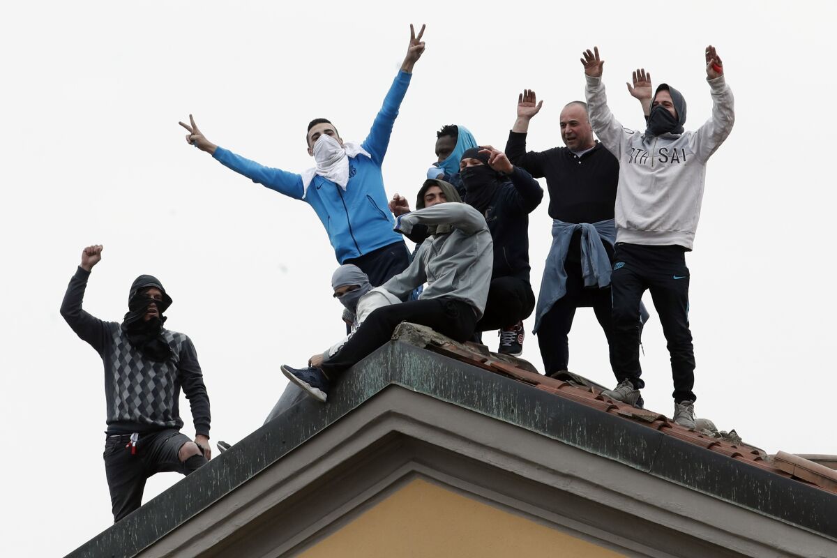 Inmates stage a protest against new rules to cope with coronavirus emergency, atop the roof of the San Vittore prison in Milan, Italy, Monday, March 9, 2020. Italy took a page from China's playbook Sunday, attempting to lock down 16 million people — more than a quarter of its population — for nearly a month to halt the relentless march of the new coronavirus across Europe. (AP Photo/Antonio Calanni)