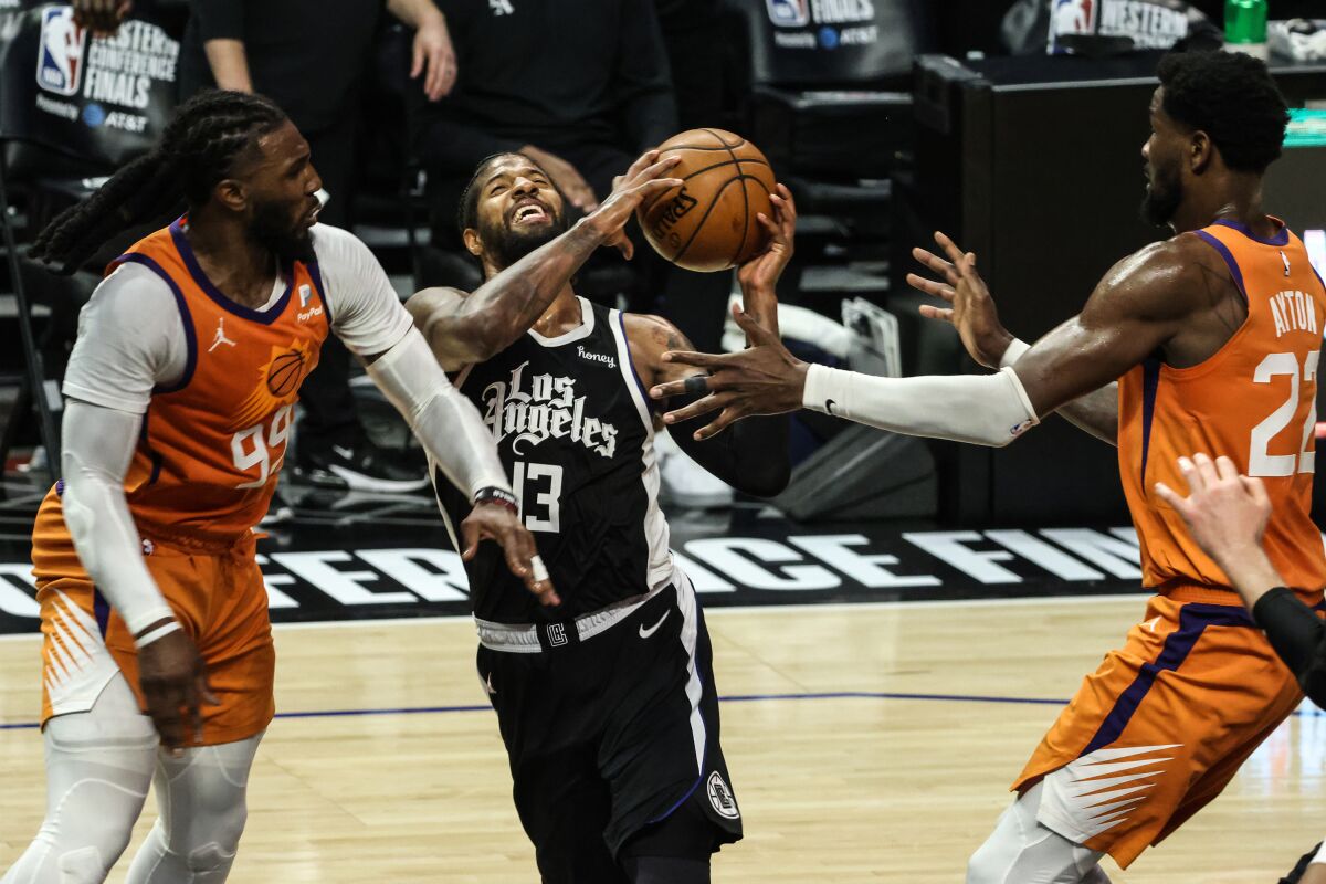 Clippers forward Paul George drives against the defense of Suns forward Jae Crowder and center Deandre Ayton during Game 3.
