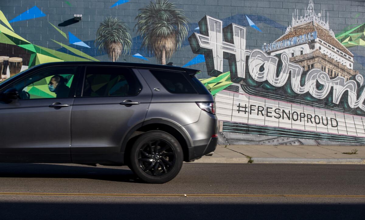 A man drives past a mural