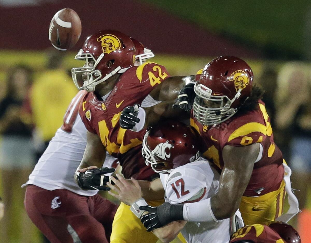 USC defensive end Leonard Williams, right, and linebacker Devon Kennard force Washington State quarterback Connor Halliday to fumble the ball during the first half of Saturday's loss to the Cougars.