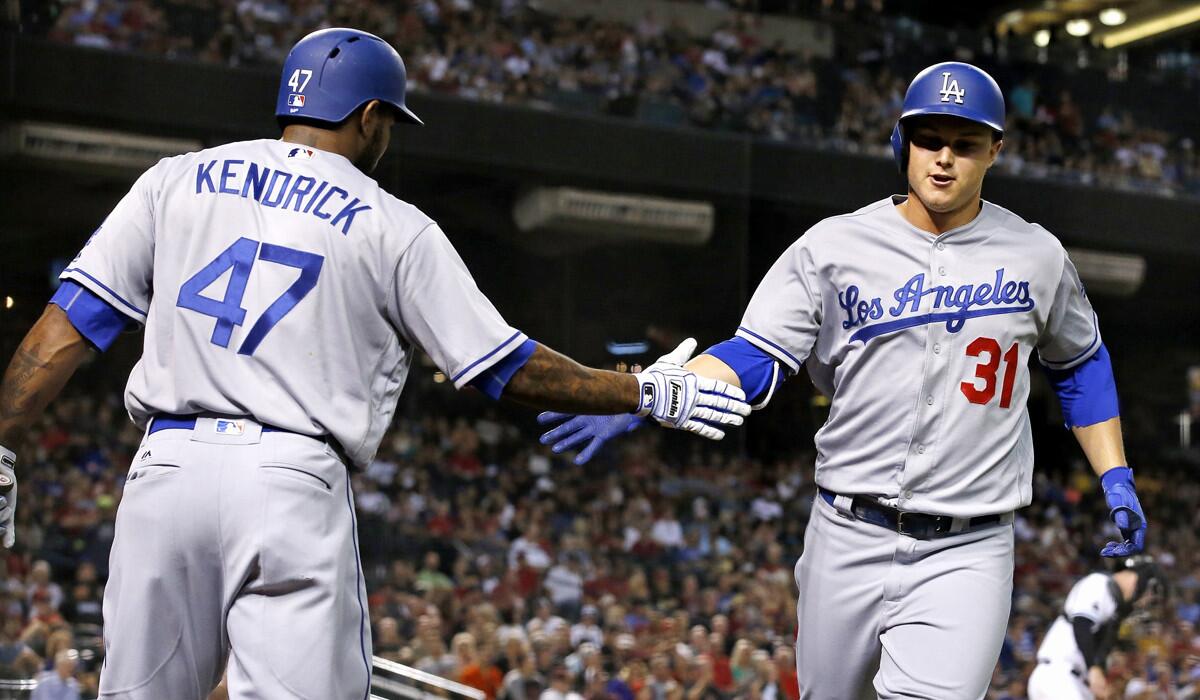 Dodgers' Joc Pederson, right, slaps hands with Howie Kendrick after Pederson's home run against the Arizona Diamondbacks during the fifth on Tuesday.