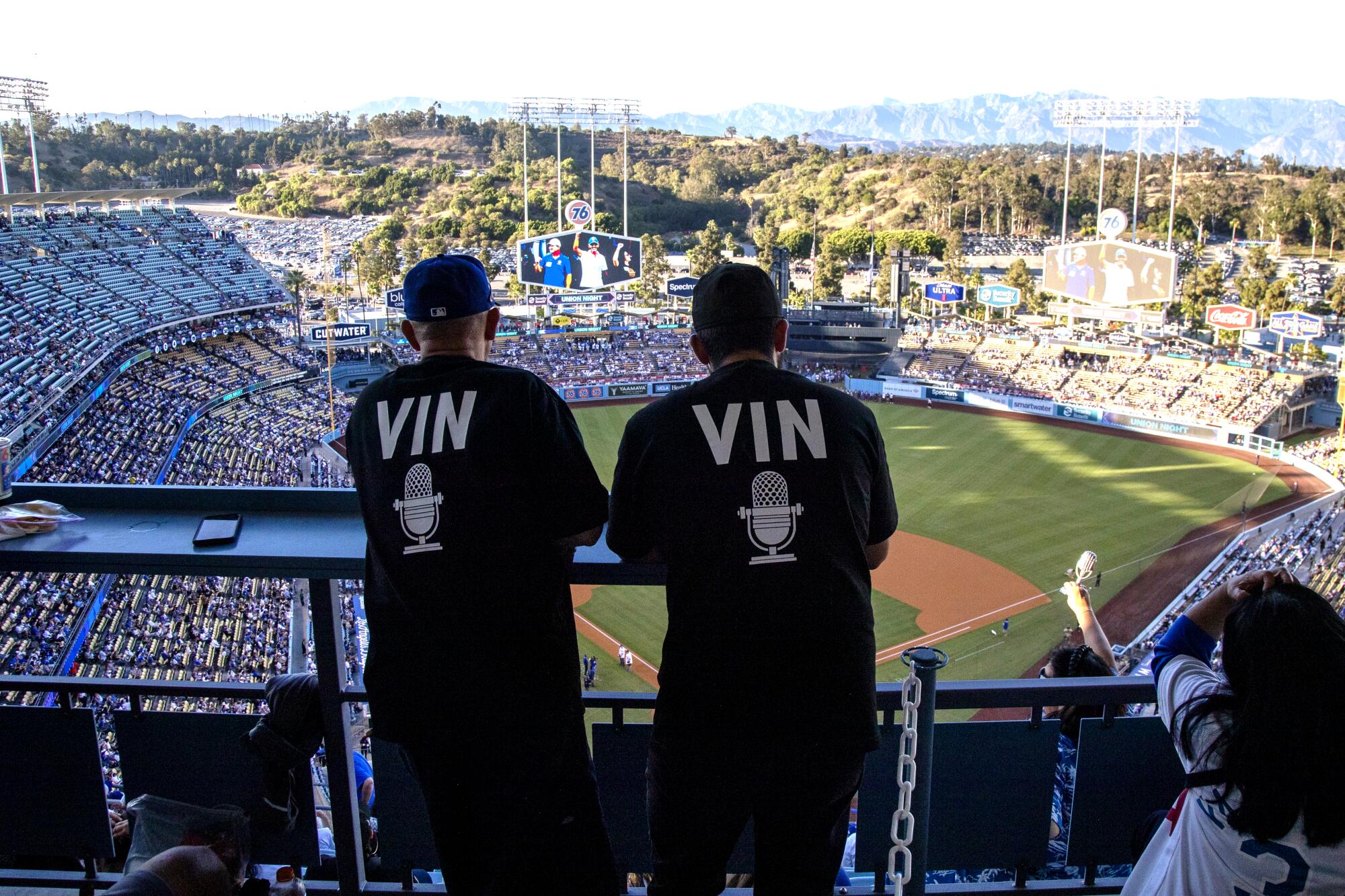 Dodger fans wear T-shirts in honor of late Dodgers announcer Vin Scully before the game at Dodger Stadium.