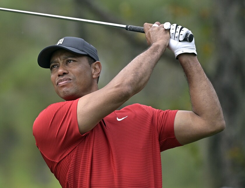 FILE - Tiger Woods watches his tee shot on the fourth hole during the final round of the PNC Championship golf tournament Dec. 20, 2020, in Orlando, Fla. Woods posted a video on social media Sunday, Nov. 21, 2021, of him swinging a wedge for the first time since badly injuring his right leg in a Feb. 23, 2021, car accident in Los Angeles. (AP Photo/Phelan M. Ebenhack, File)