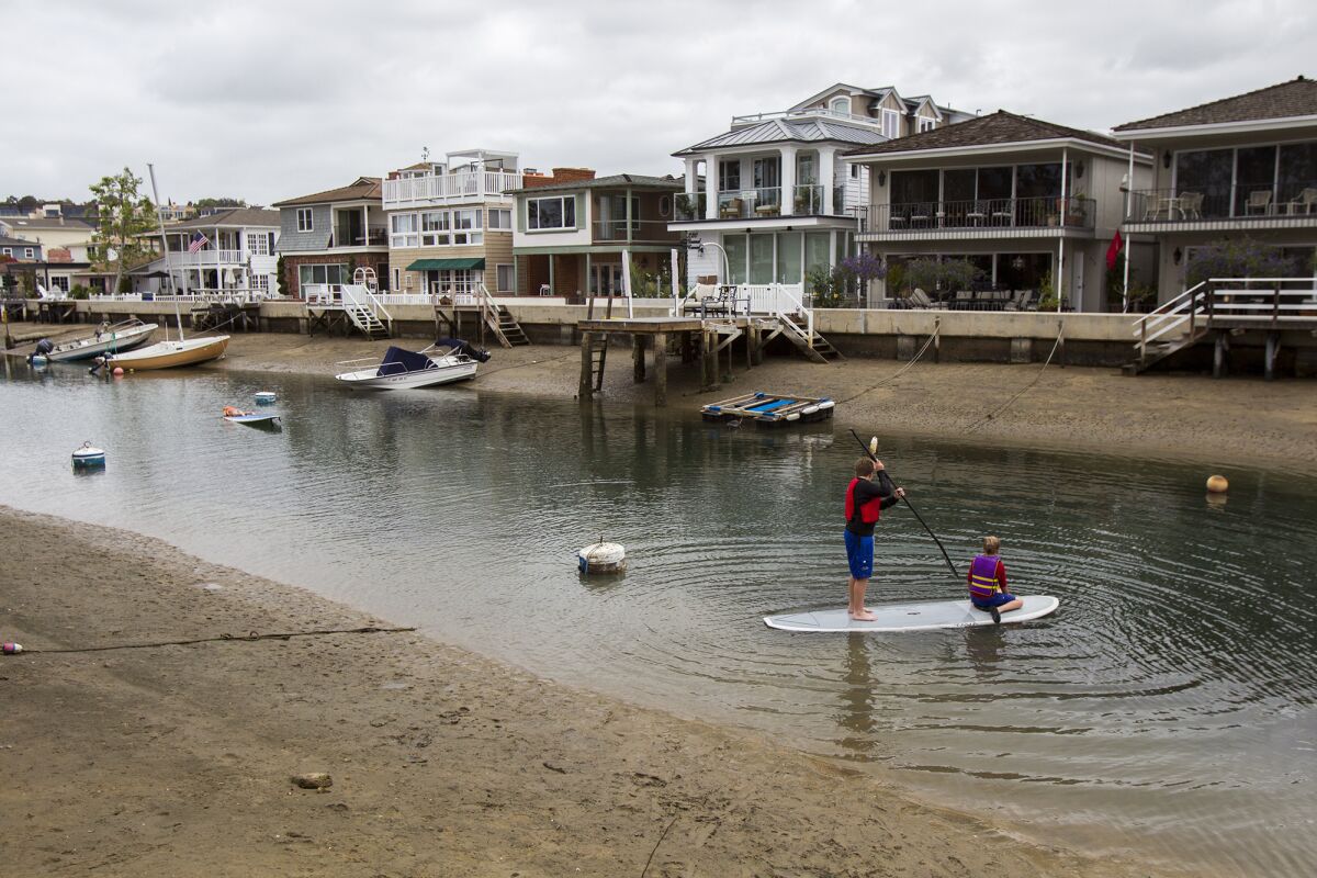 Charlie and Carson Geiling paddle through the Grand Canal that runs between Balboa Island last year.
