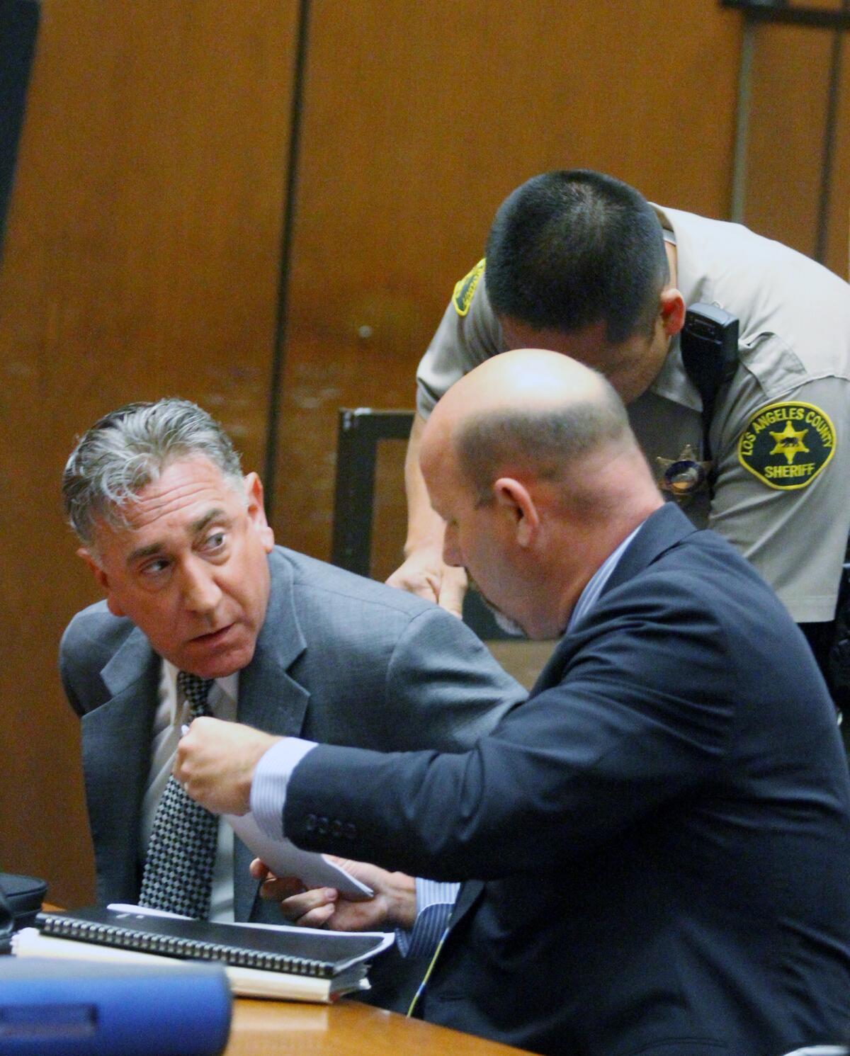 Former Glendale Mayor John Drayman, after being sentenced, is put in handcuffs by a Los Angeles County Sheriff's deputy with his lawyer Sean McDonald at his side at Superior Court in Los Angeles on Monday, April 7, 2014 for embezzling proceeds from the Montrose Farmer's Market, and filing false tax returns. After spending eight days in jail, Drayman was transferred to home confinement, with his sentence due to end this Sunday.