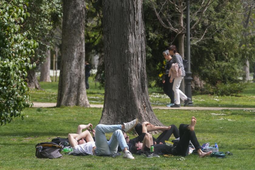 ARCHIVO - Varias personas descansan en el parque del Retiro el miércoles 20 de marzo de 2024, en Madrid, España. (AP Foto/Paul White, archivo)