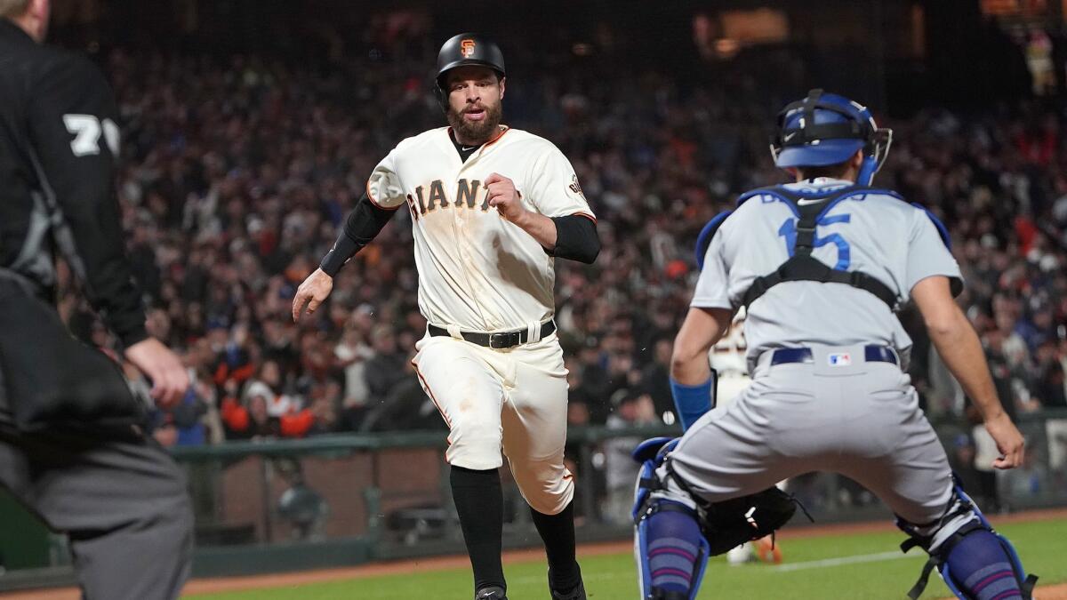 Brandon Belt (9) of the San Francisco Giants scores the go ahead run against the Dodgers in the bottom of the seventh inning at Oracle Park.