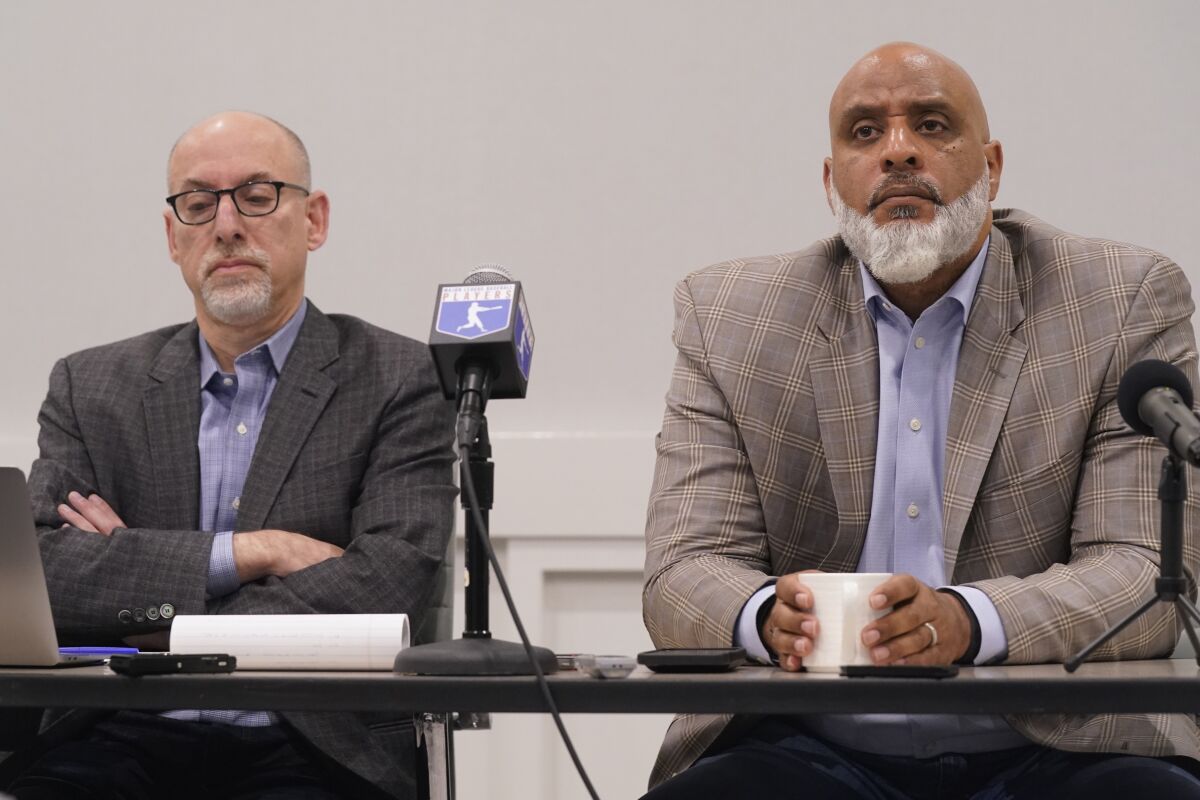 MLB union chief Tony Clark, right, and lead union negotiator Bruce Meyer listen to a question during a news conference