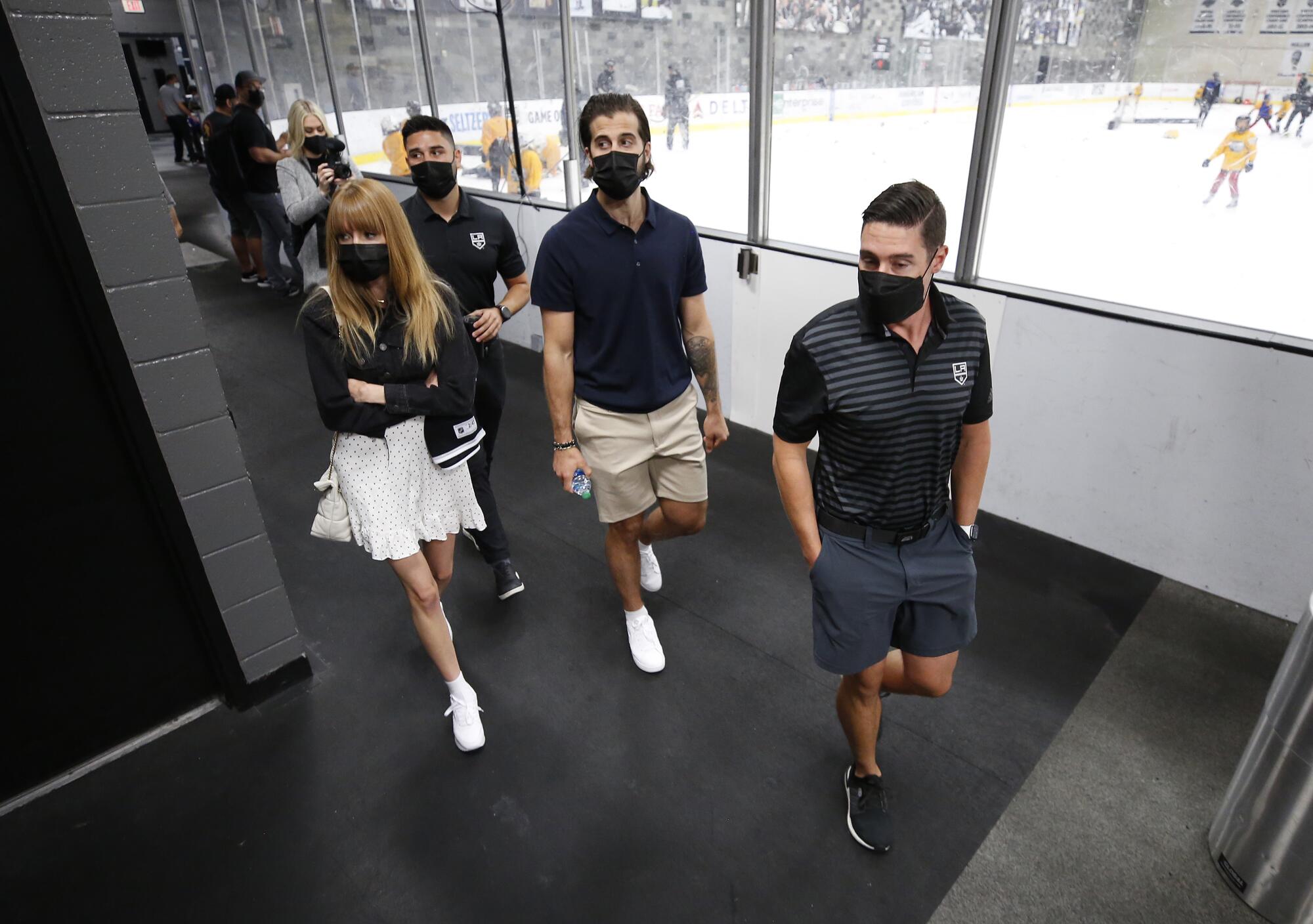 Jeff Andrews, assistant athletic trainer, leads Phillip and Marie Danault on their tour, walking past an ice rink