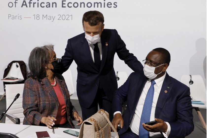 FILE - French President Emmanuel Macron, center, salutes Ethiopia's President Sahle-Work Zewde, left, and Senegal's President Macky Sall at the Summit on the Financing of African Economies on May 18, 2021 in Paris. European Union leaders want to re-engage with African nations and counter the growing influence from China and Russia across the continent during a two-day summit in Brussels.The EU-African Union gathering starting Thursday, Feb. 17, 2022, was initially planned for 2020 but was postponed due to the coronavirus pandemic and agenda issues. So it's the first time EU and African Union leaders meet in that format since 2017. (Photo by Ludovic Marin, Pool via AP)