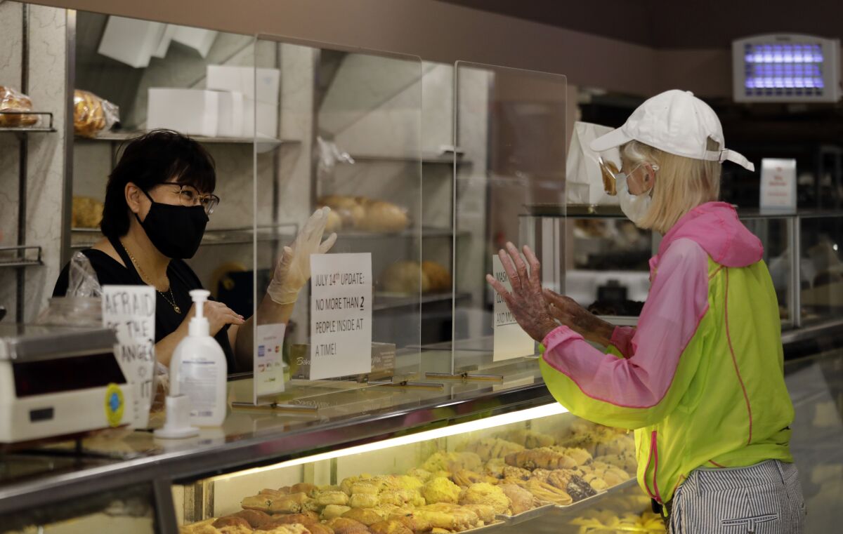  Diamond Bakery employee Raida Shieban helps longtime customer Virginia Karp. 