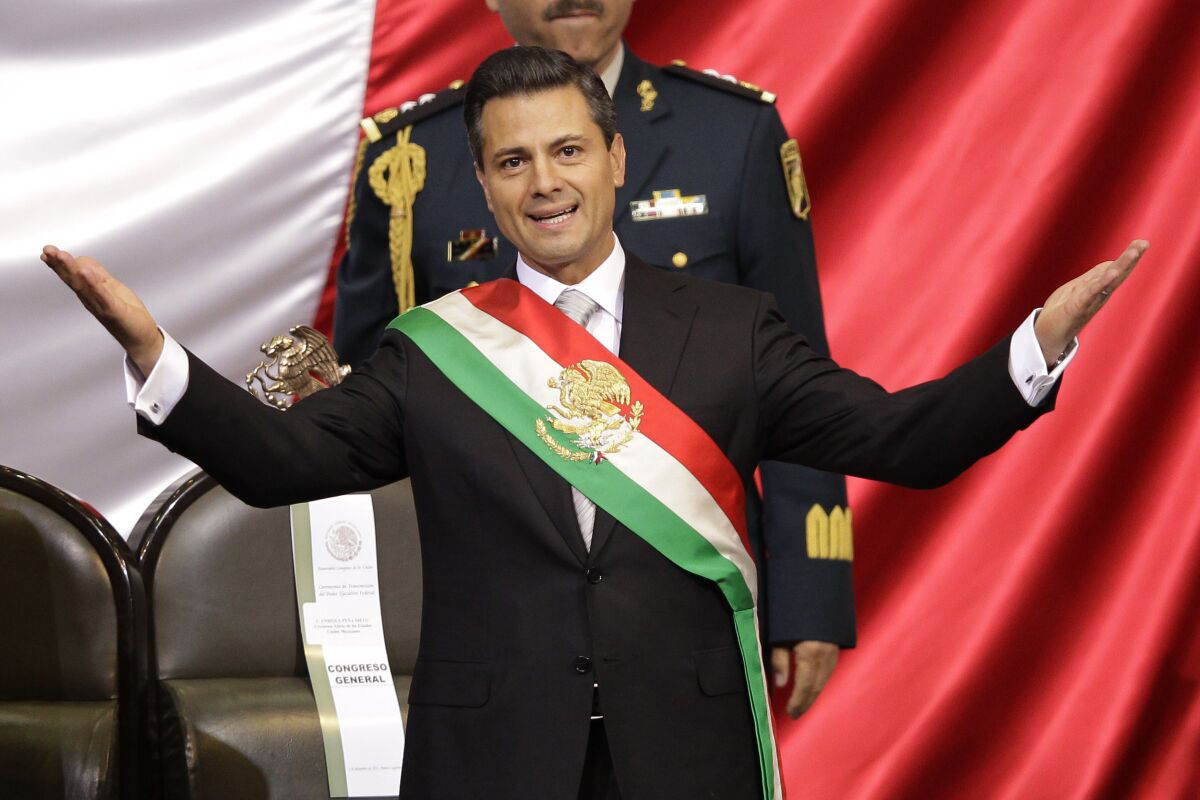 FILE - Mexico's incoming President Enrique Pena Nieto of the Institutional Revolution Party (PRI) wears the presidential sash after being sworn-in at his inauguration ceremony before Congress in Mexico City, Dec. 1, 2012. Mexico’s anti-money laundering agency said on July 7, 2022 it has accused Peña Nieto of handling millions of dollars in possibly illegal funds. (AP Photo/Alexandre Meneghini, File)