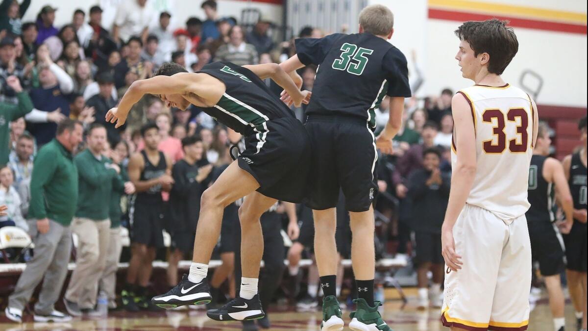 Costa Mesa High's Tre Villalpando (5) and George Williamson (35) celebrate a last-second shot to close out the first half of an Orange Coast League game at Estancia on Wednesday.