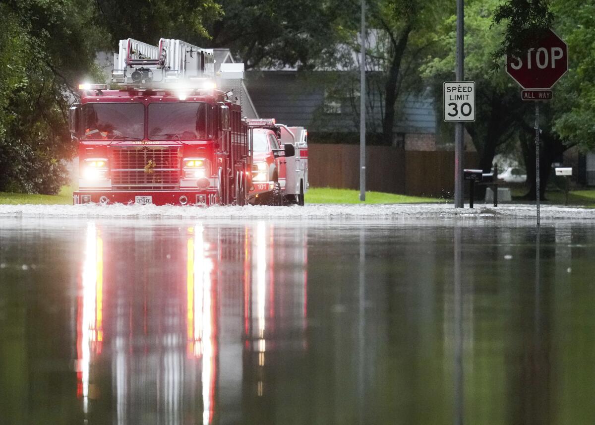 Un camión de bomberos de Houston atraviesa un camino inundado en North Woodland Hills 