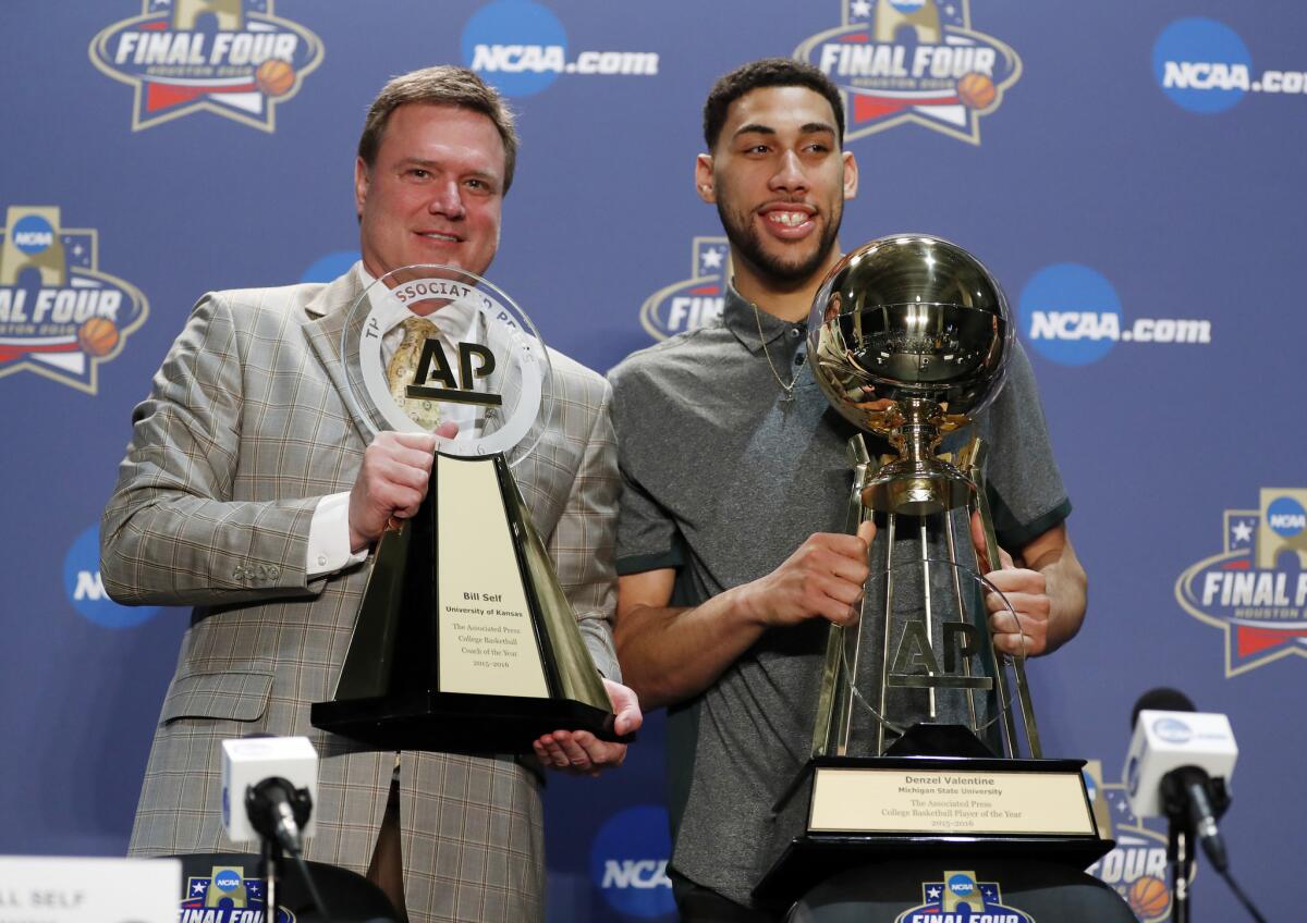 Kansas Coach Bill Self and Michigan State's Denzel Valentine hold their trophies at a news conference Thursday in Houston.