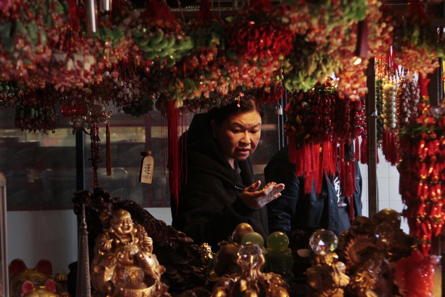 Elisa Aquino of Carson shops at a kiosk owned by Stephani Yuan in Chinatown in Los Angeles.