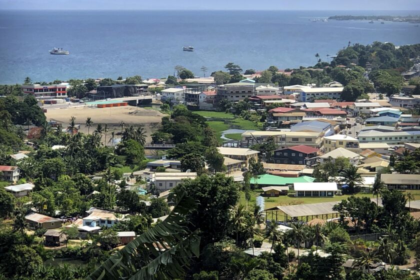 FILE - Ships are docked offshore in Honiara, the capital of the Solomon Islands, Nov. 24, 2018. The Solomon Islands' decision to switch its diplomatic allegiance from Taiwan to Beijing in 2019, has been blamed for arson and looting in the capital Honiara, where protesters are demanding the prime minister's resignation.(AP Photo/Mark Schiefelbein, File)