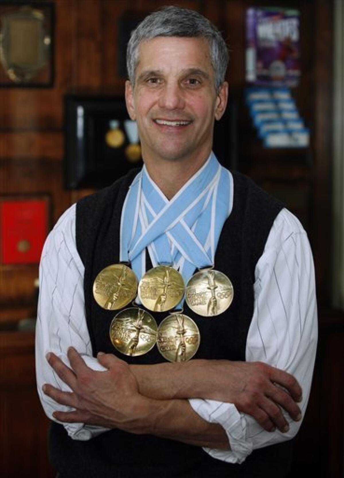 Dr. Eric Heiden, winner of 5 gold medals in speed skating at the 1980 Olympic Games in Lake Placid, is shown with his medals infront of a display case of memorabilia at his medical practice Friday, Jan. 29, 2010, in Park City, Utah. Heiden also raced bicycles in the 1986 Tour de France before going on to medical school and becoming an Orthopedic Surgeon. (AP Photo/Steve C. Wilson)