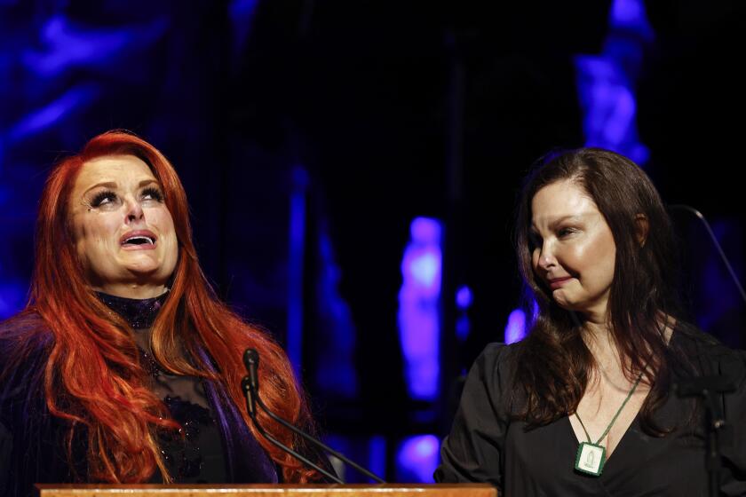 Wynonna Judd, left, looks to the sky as sister Ashley Judd watches during the Medallion Ceremony at the Country Music Hall Of Fame Sunday, May 1, 2022, in Nashville, Tenn. (Photo by Wade Payne/Invision/AP)