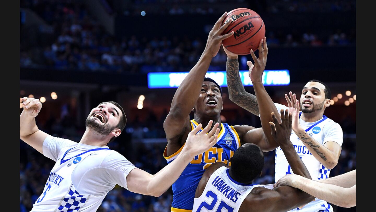 UCLA's Ike Anigbogu grabs a rebound in front of a crowd of Kentucky players during the first half of a Sweet 16 game on March 24.