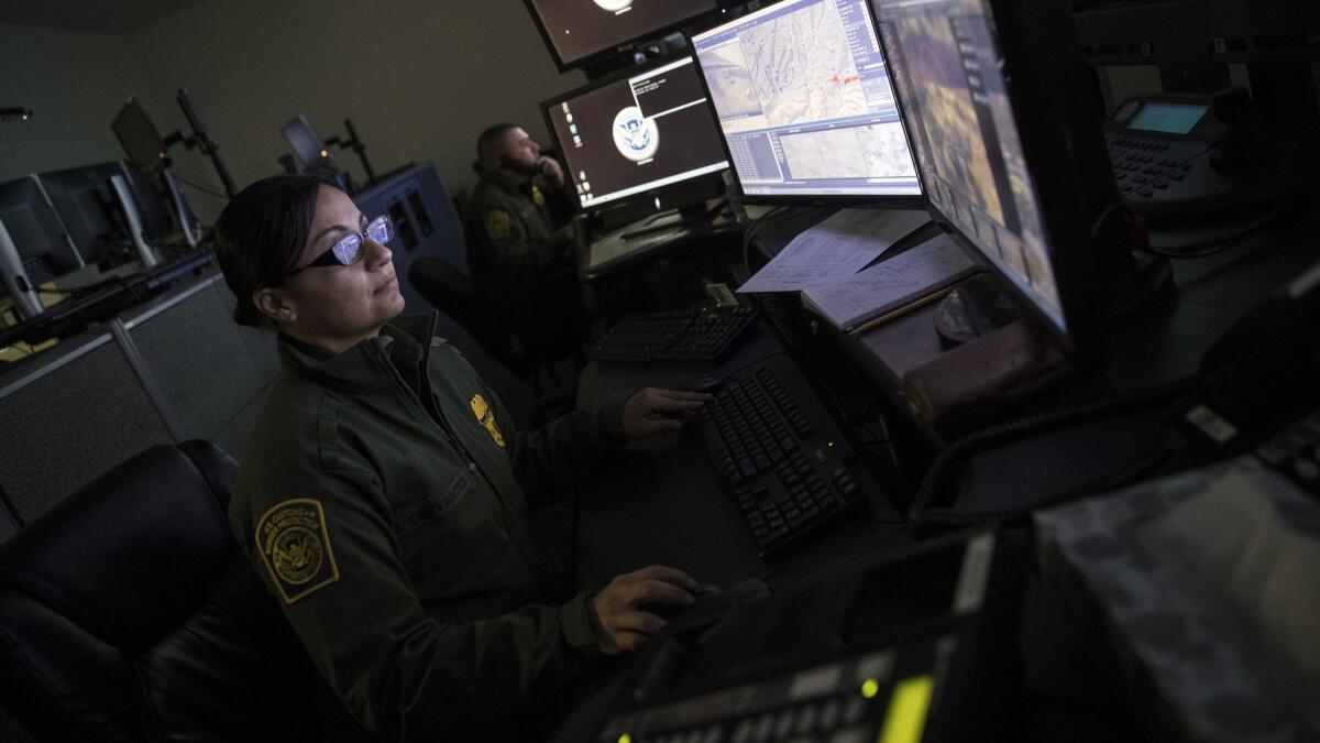 U.S. Border Patrol agents monitor security footage at a facility in Nogales, Ariz.