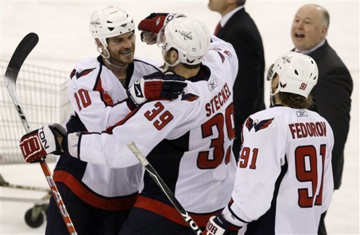 Washington Capitals' David Steckel (39) celebrates his overtime goal against the Pittsburgh Penguins with teammates Matt Bradley (10), Sergei Fedorov (91) of Russia, and coach Bruce Boudreau, right rear, in Game 6 of an NHL hockey second-round playoff series, in Pittsburgh on Monday, May 11, 2009. The Capitals won 5-4. (AP Photo/Gene J. Puskar)