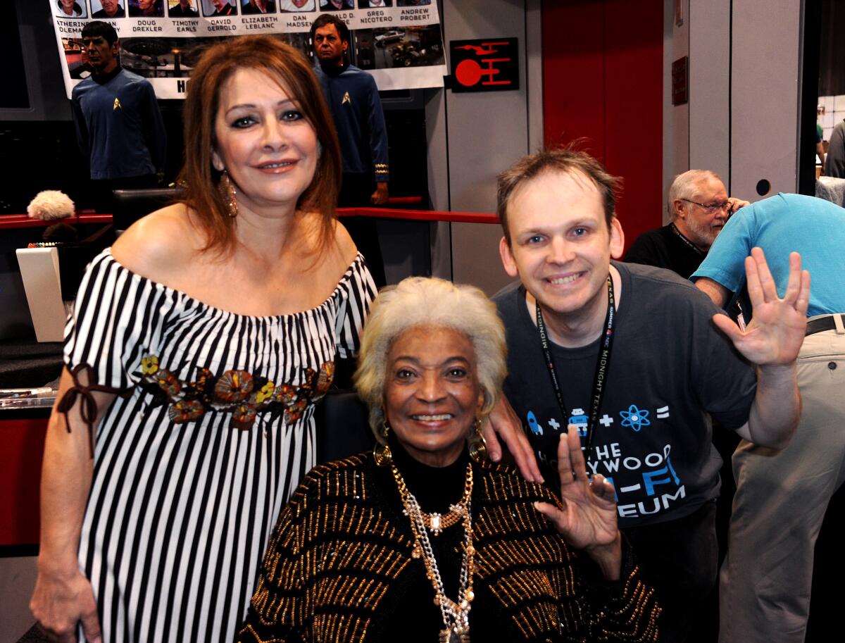 Marina Sirtis and Nichelle Nichols and Huston Huddleston, who are doing the Vulcan salute, smile for cameras. 