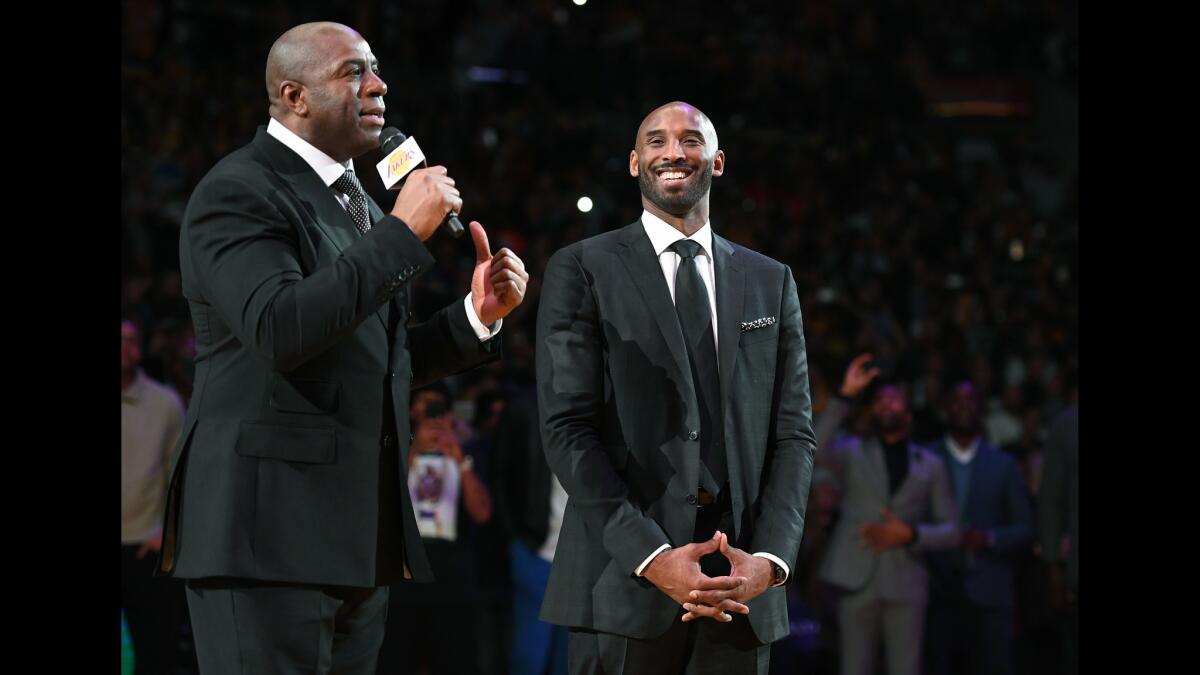 Former Lakers guard Magic Johnson, left, praises Kobe Bryant during the ceremony to retire his two jerseys on Dec. 18, 2017.