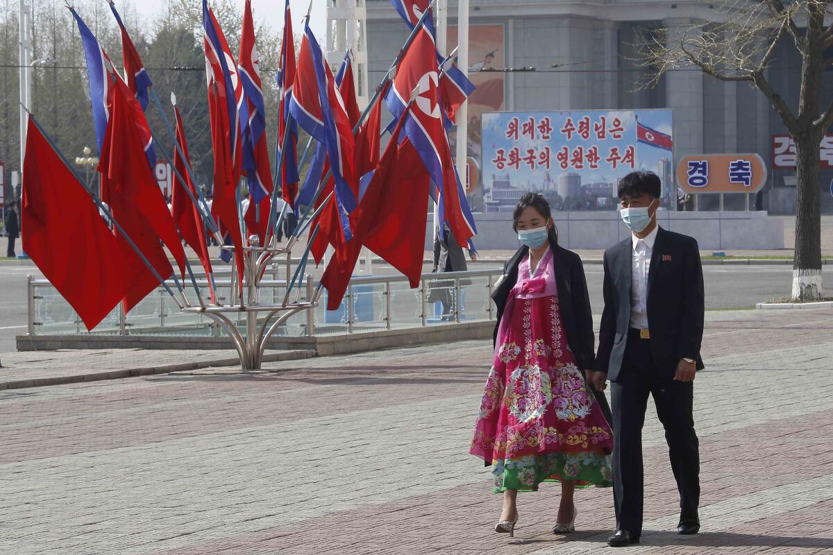 Couple walking along street in Pyongyang, North Korea