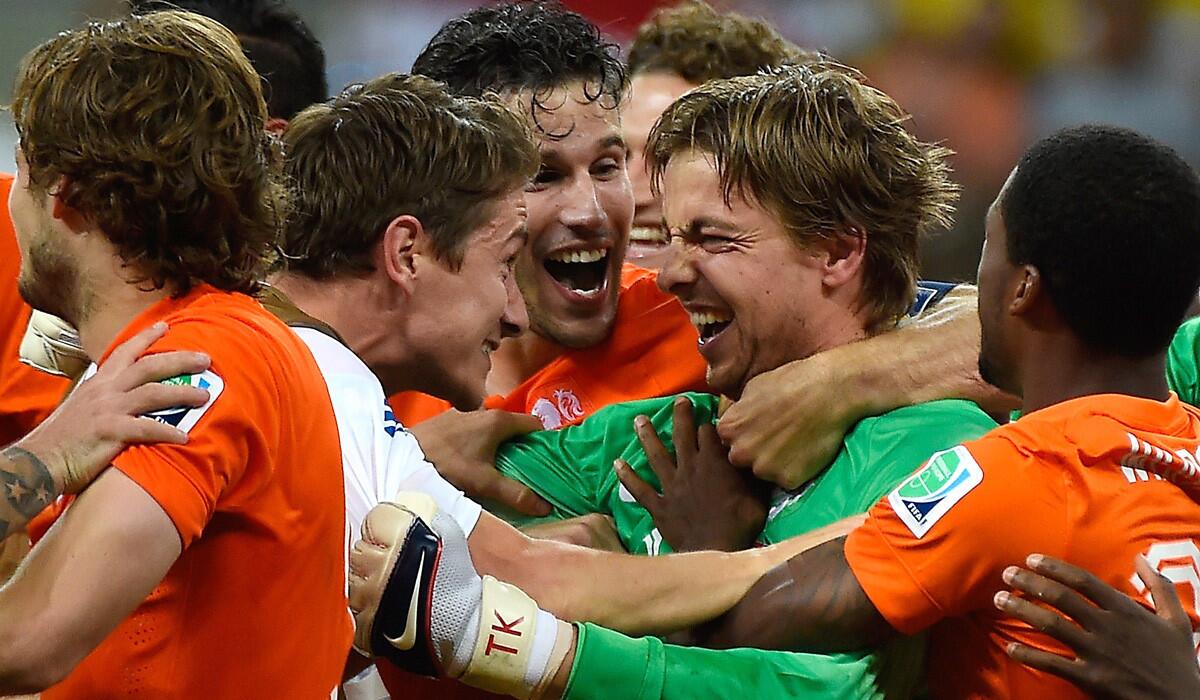 Netherlands players celebrate with goalkeeper Tim Krul (green) after he blocked two penalty kicks by Costa Rica in a quarterfinal shootout victory on Saturday at Fonte Nova Arena in Salvador, Brazil.