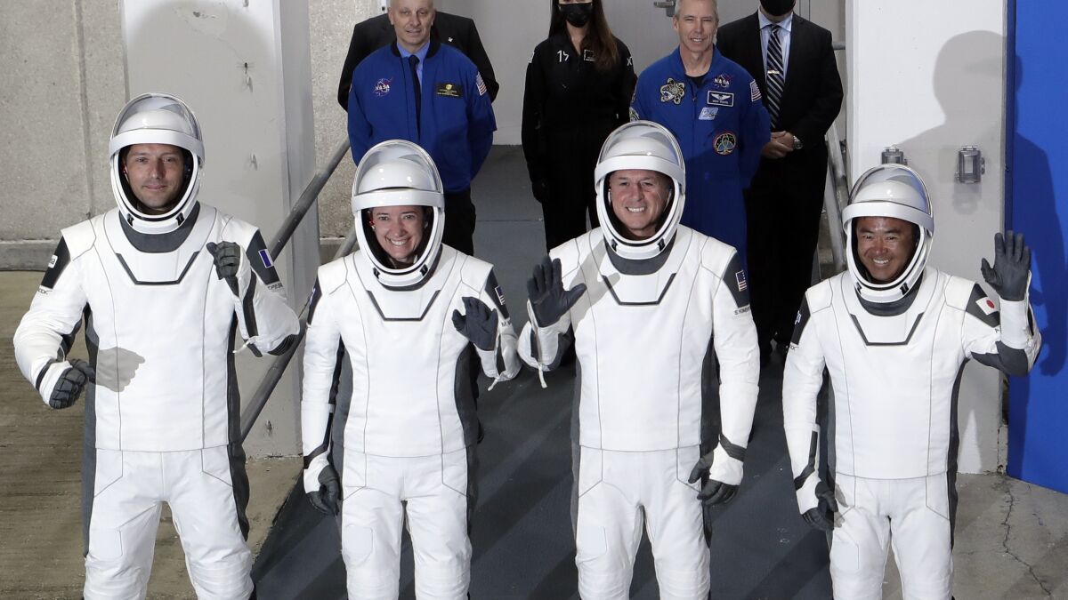 FILE - From front left, European Space Agency astronaut Thomas Pesquet, NASA astronaut Megan McArthur, NASA astronaut Shane Kimbrough and Japan Aerospace Exploration Agency astronaut Akihiko Hoshide leave the Operation and Checkout Building at the Kennedy Space Center in Cape Canaveral, Fla., Friday, April 23, 2021. High wind off the Florida coast has prompted SpaceX to delay the return of four space station astronauts. They were supposed to leave the International Space Station on Sunday, Nov. 7, 2021 with their capsule splashing down in the Gulf of Mexico on Monday morning. (AP Photo/John Raoux, file)