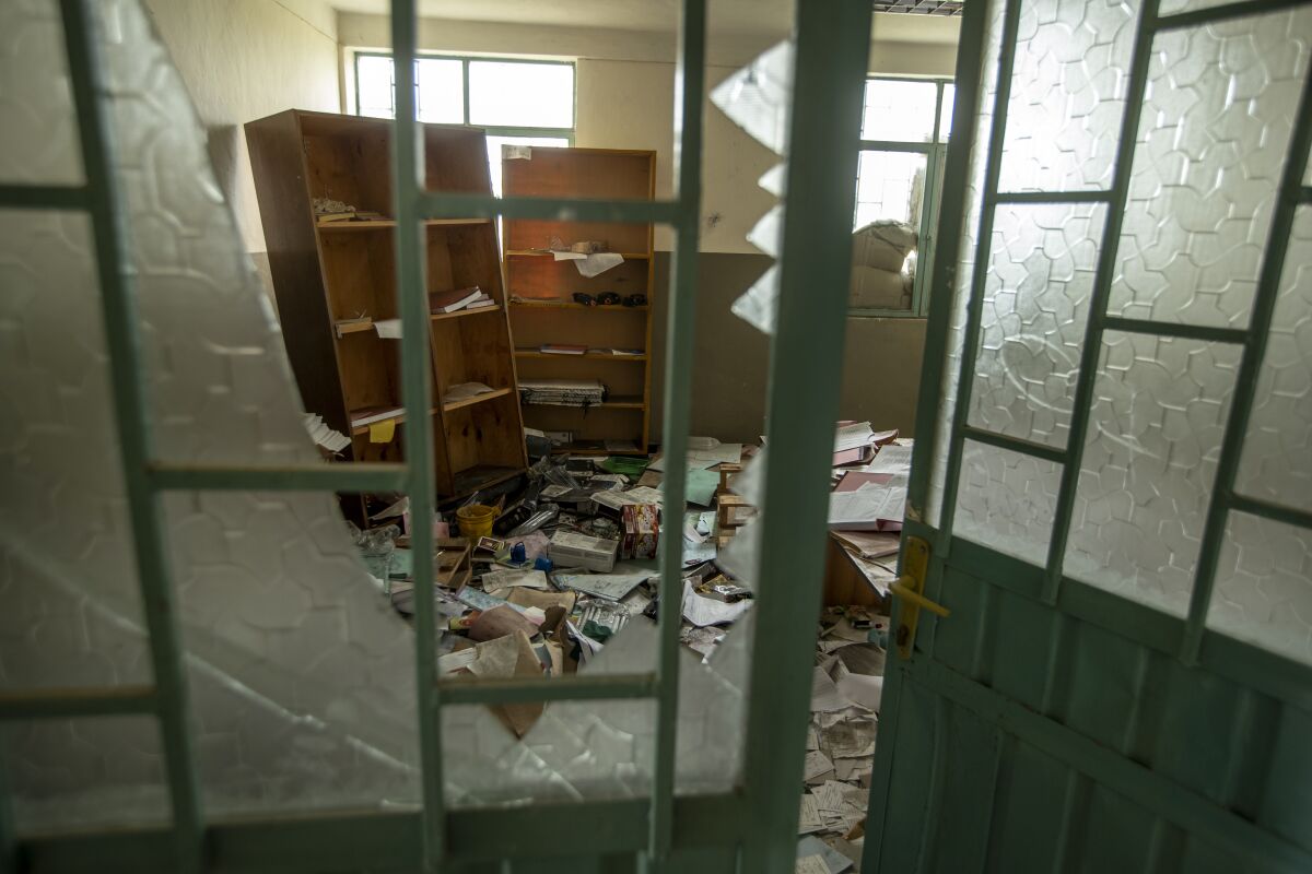 A ransacked hospital room is seen through a broken window.