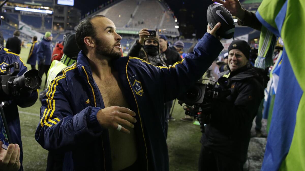 Galaxy forward Landon Donovan hands back a football he autographed for a fan after the Galaxy's match against the Seattle Sounders in the MLS Western Conference final on Sunday.