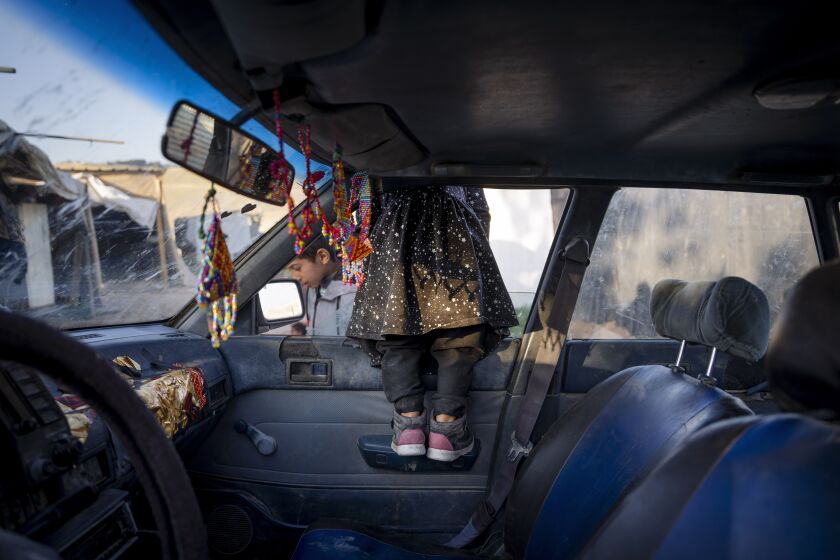 A young Bedouin girl looks to of a car window at the West Bank hamlet of Khan al-Ahmar, Sunday, Jan. 22, 2023. The long-running dispute over the West Bank Bedouin community of Khan al-Ahmar, which lost its last legal protection against demolition four years ago, resurfaced this week as a focus of the frozen Israeli-Palestinian conflict. Israel's new far-right ministers vow to evacuate the village as part of a wider project to expand Israeli presence in the 60% of the West Bank over which the military has full control. Palestinians seek that land for a future state. (AP Photo/Oded Balilty)