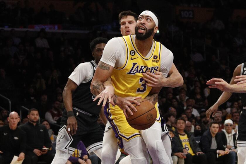 Lakers forward Anthony Davis (3) gets wrapped up by San Antonio Spurs forward Doug McDermott.