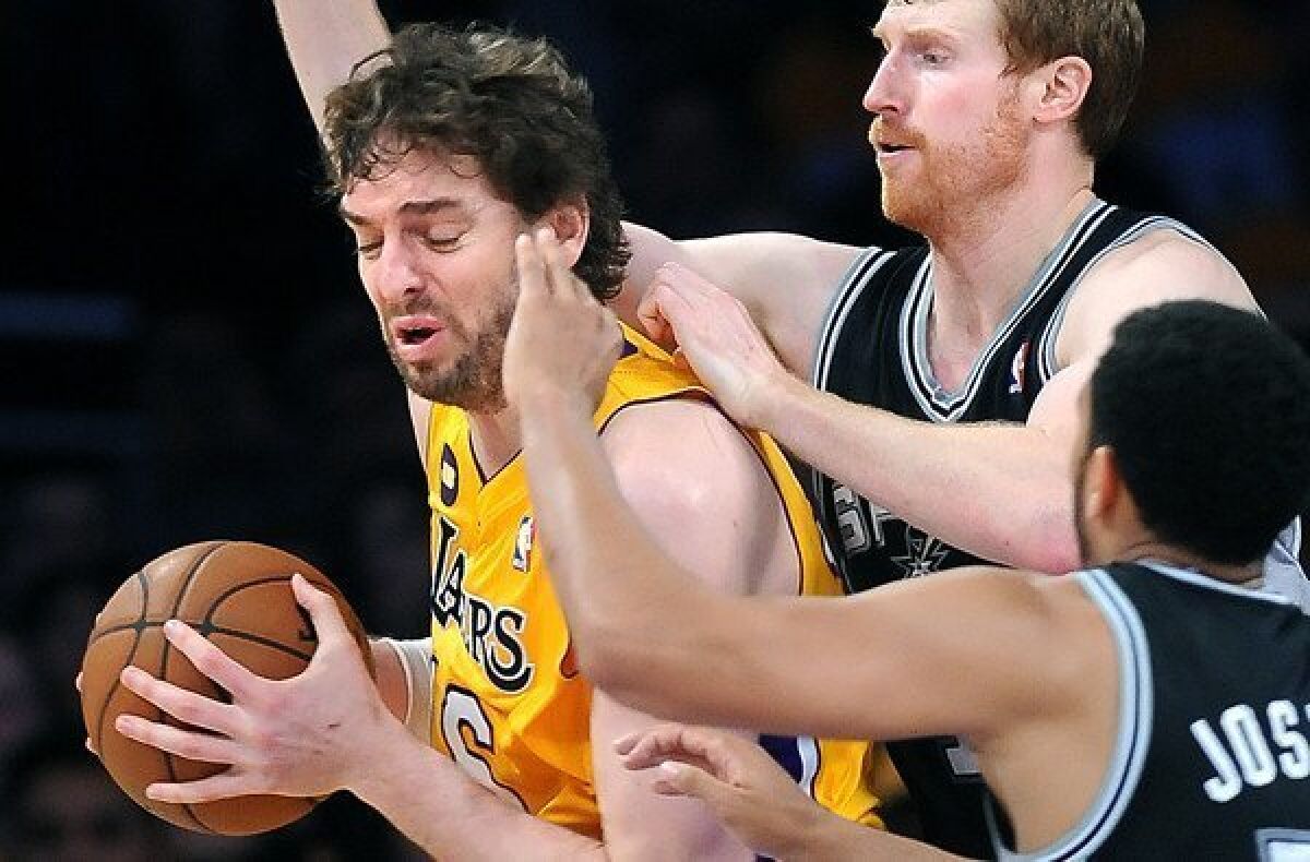 Lakers power forward Pau Gasol is swarmed by the double-team defense of Spurs forward Matt Bonner and guard Cory Joseph on Friday night at Staples Center.